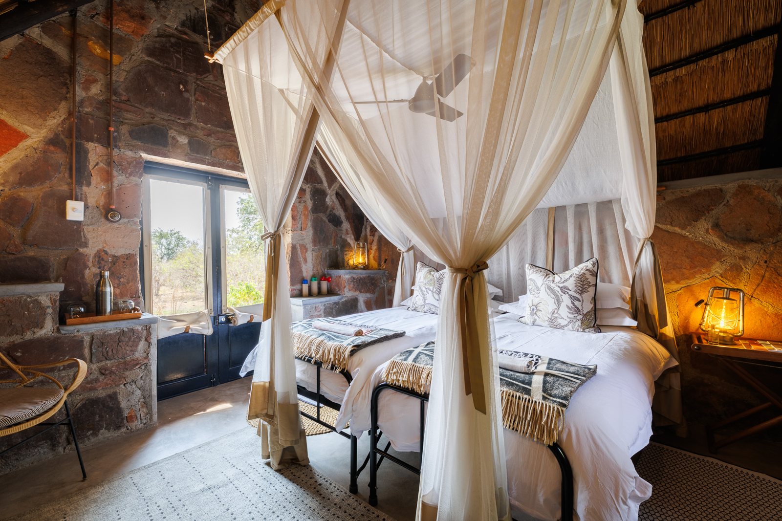 A chalet bedroom with a netted bed and stone walls