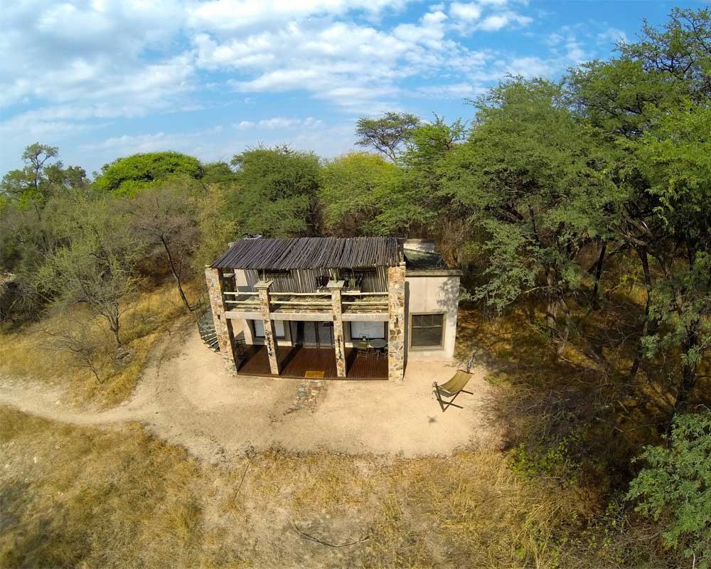A Camelthorn Lodge villa sits in dense green bush, seen from above