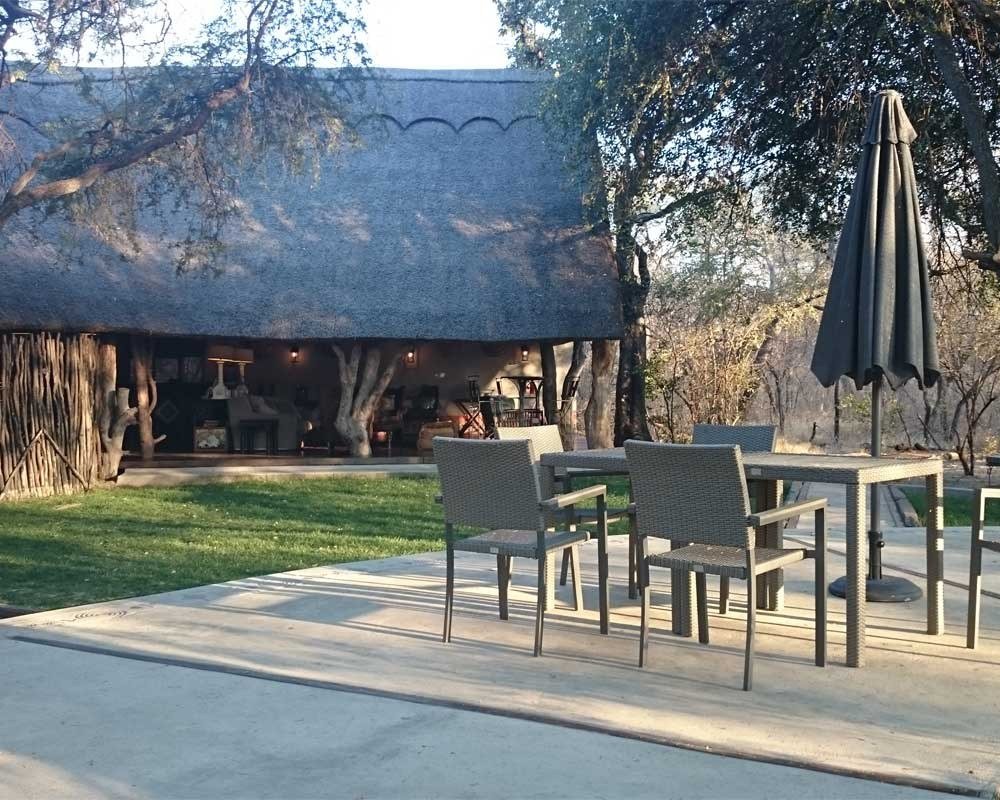 Camelthorn Lodge's thatched main building has an outdoor dining terrace
