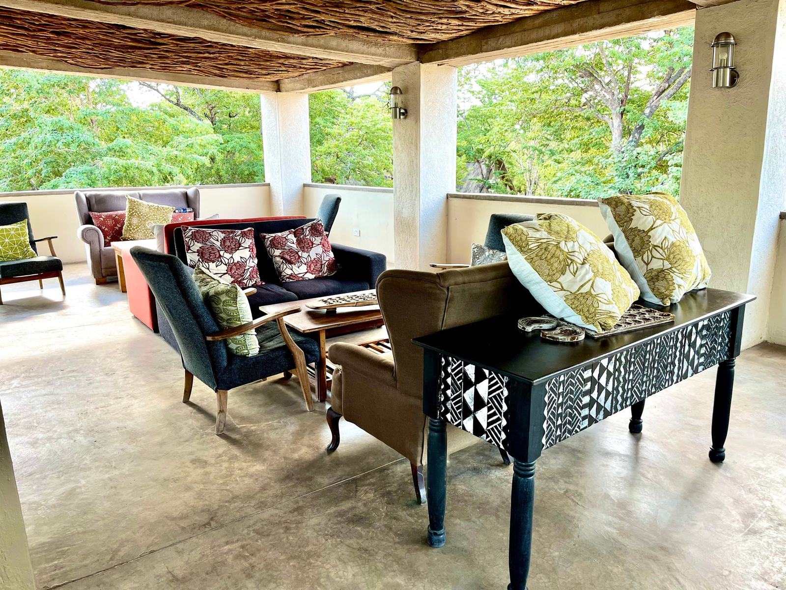 Gwango Heritage Resort's shaded lounge has sofas and armchairs open to the trees