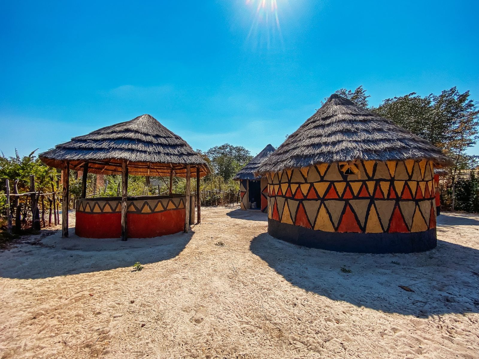 Painted round huts with thatched roofs stand in Gwango Heritage Resort's cultural village