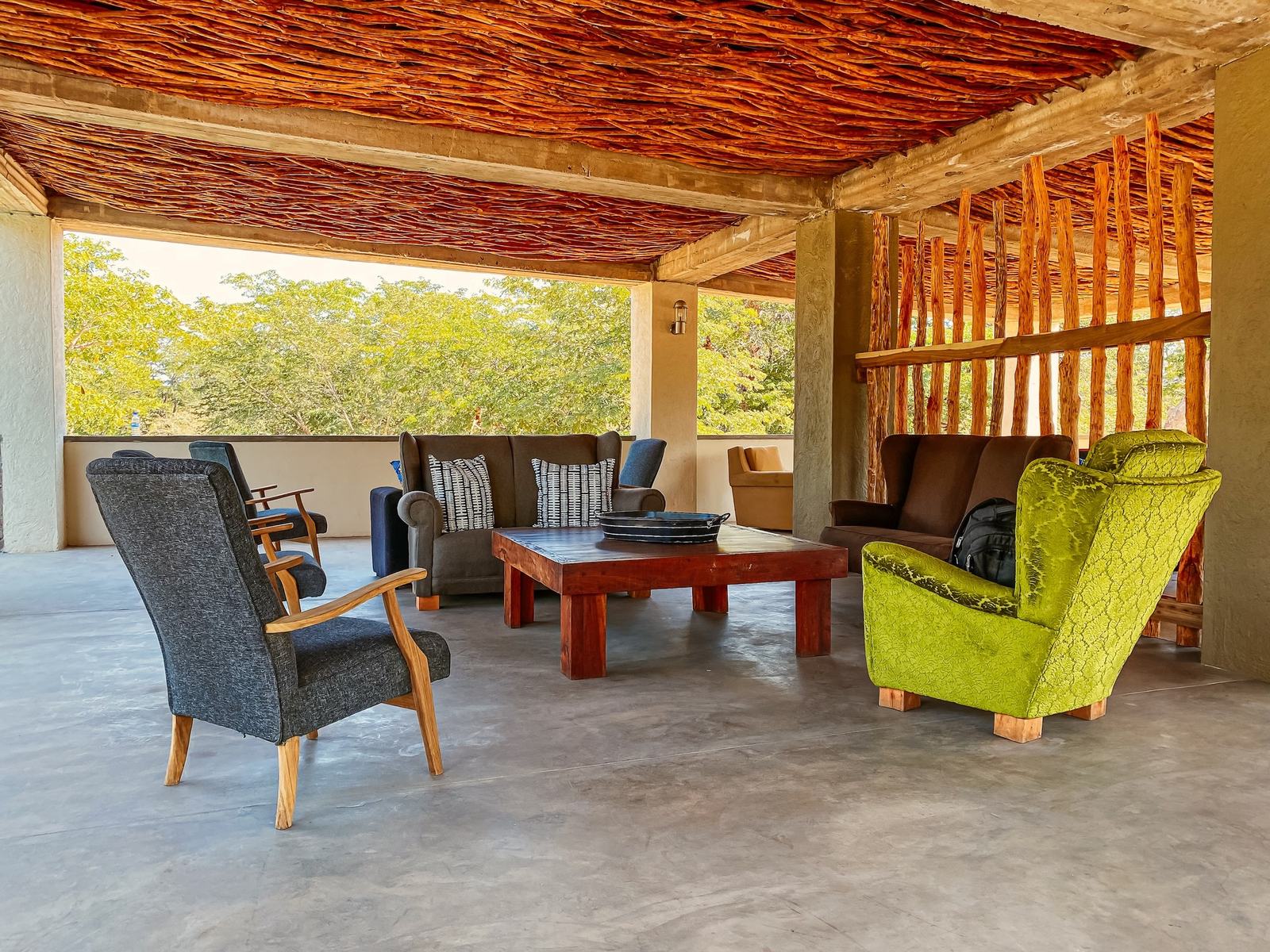 An open-sided lounge at Gwango Heritage Resort has armchairs under a reed ceiling