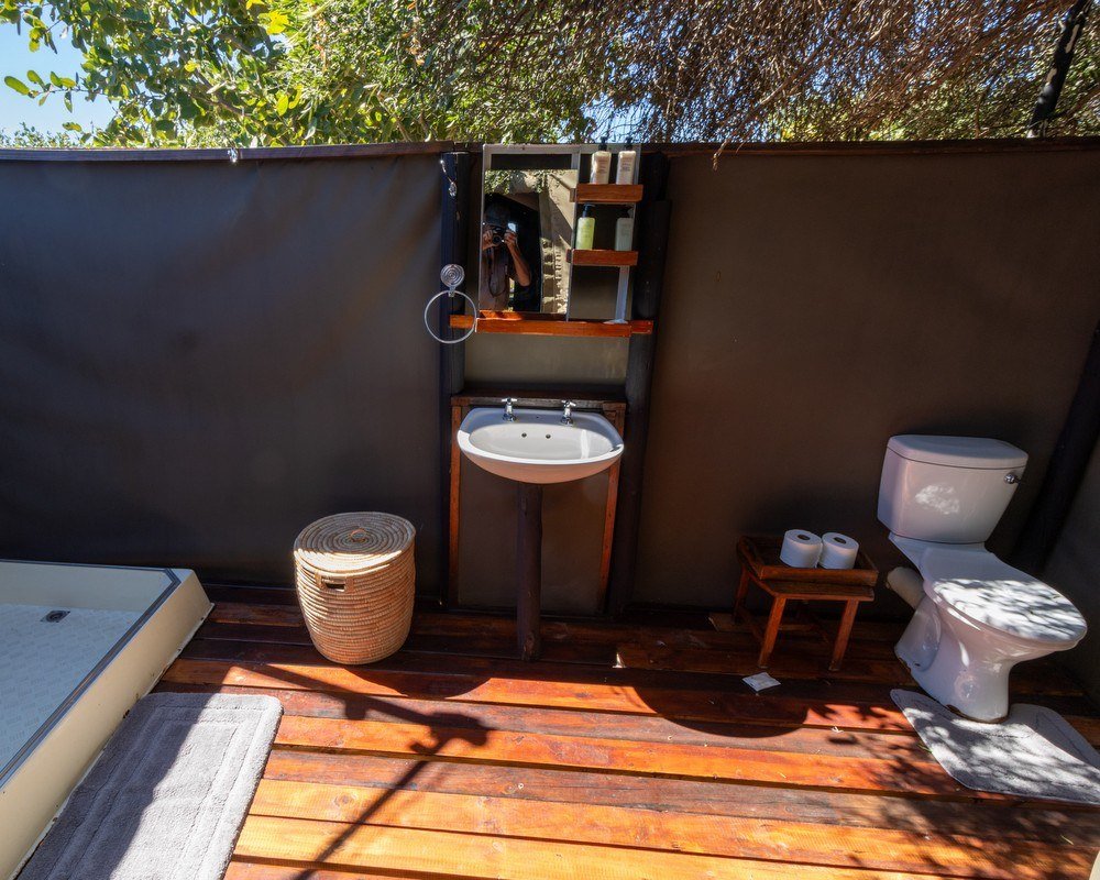 Jozibanini Camp's open-air bathroom has a basin, toilet and wooden decking