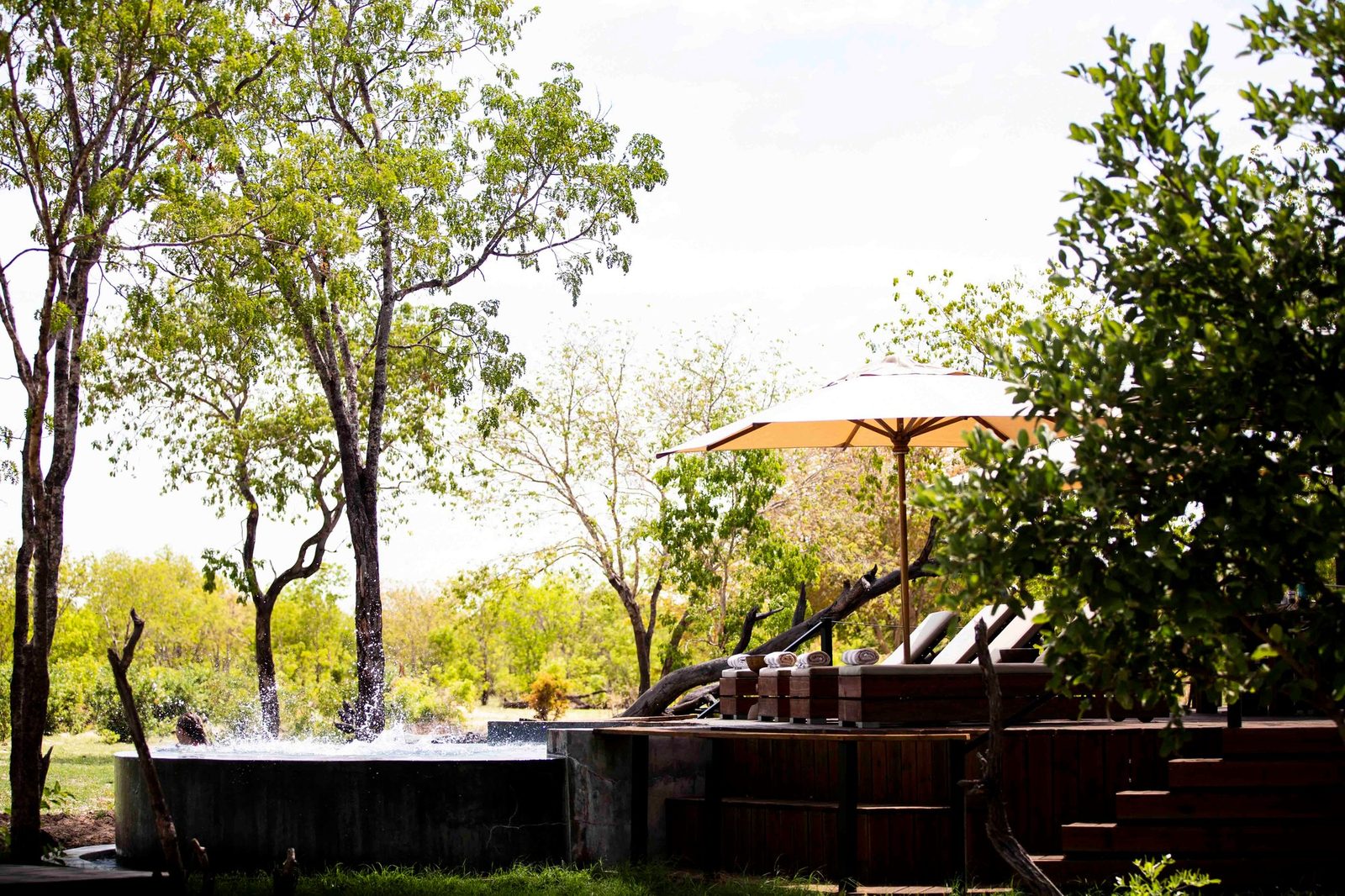 The plunge pool and sun loungers at Wilderness Little Makalolo sit under a shade umbrella