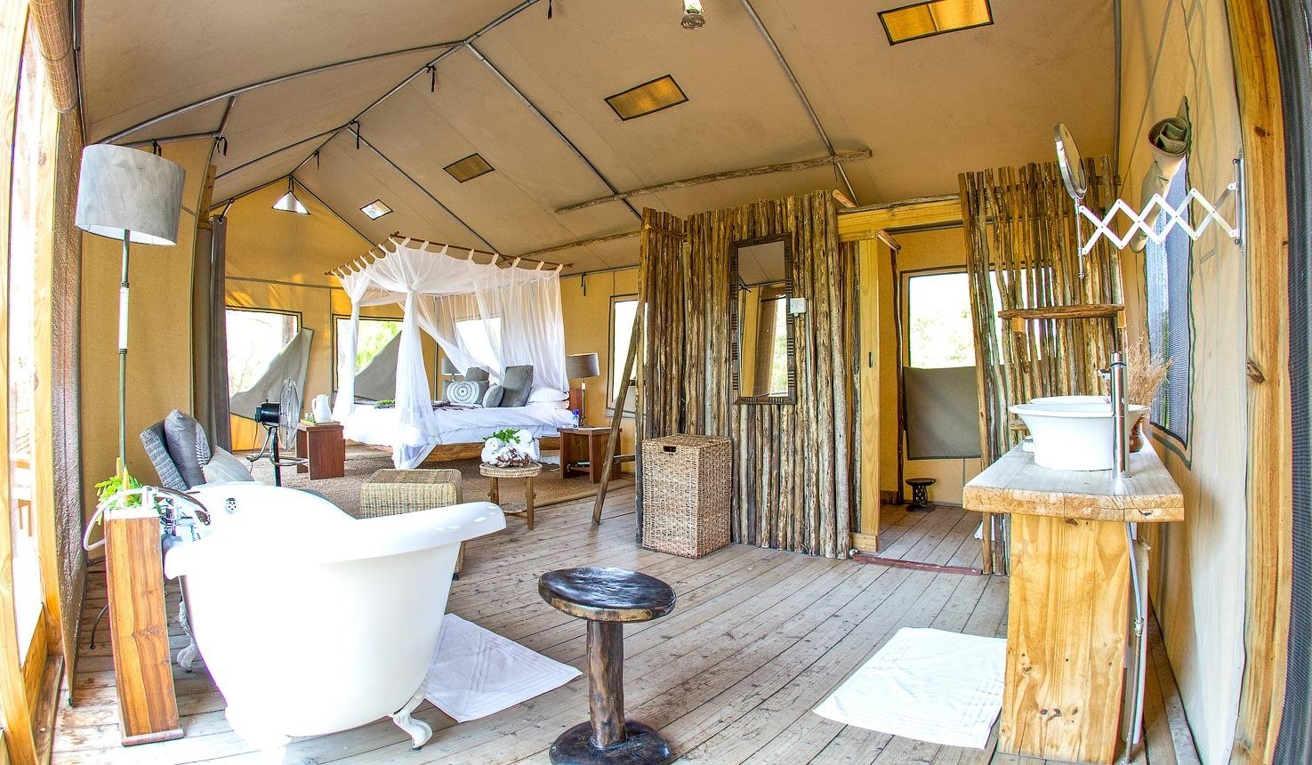 A freestanding bath and basin on a stand furnish a tent at Miombo Safari Camp