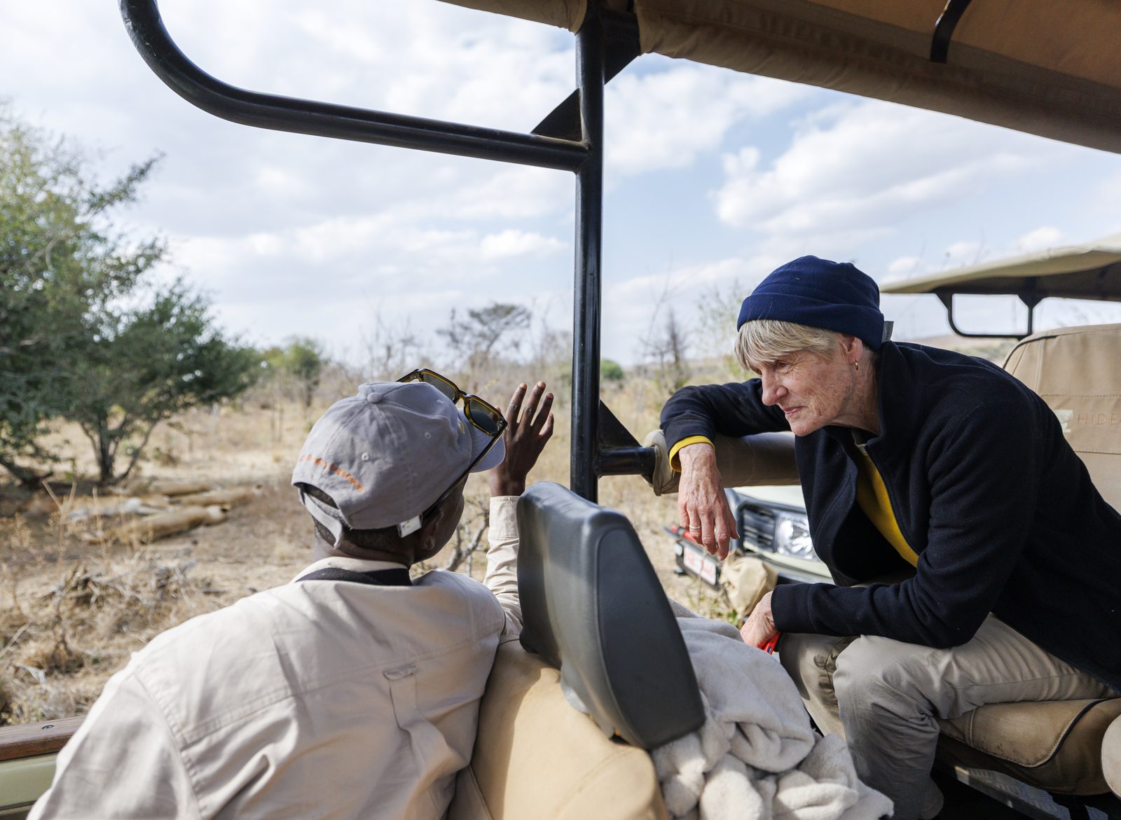 A guide talking a guest through a sighting from the driver's seat