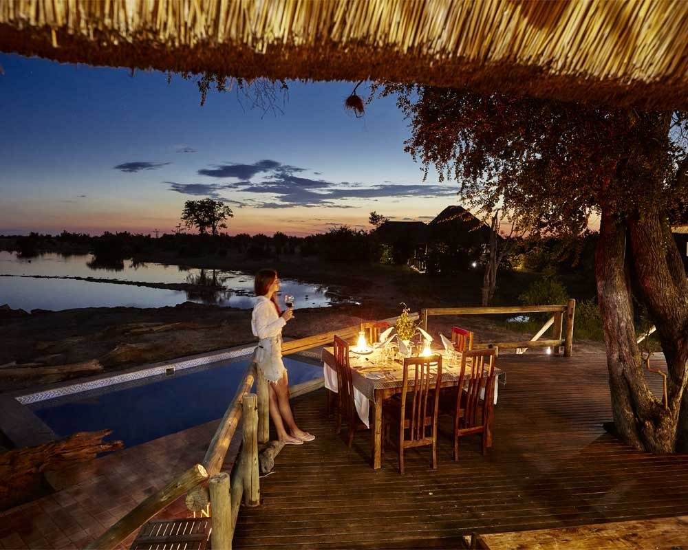 Dinner is set beside the pool at Nehimba Lodge at dusk, overlooking the pan