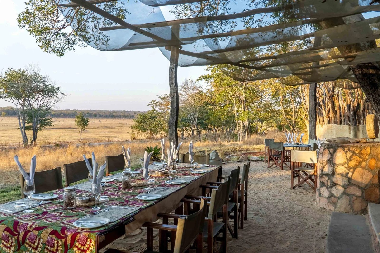 The long dining table at Sable Valley Lodge sits under a shade net above the vlei