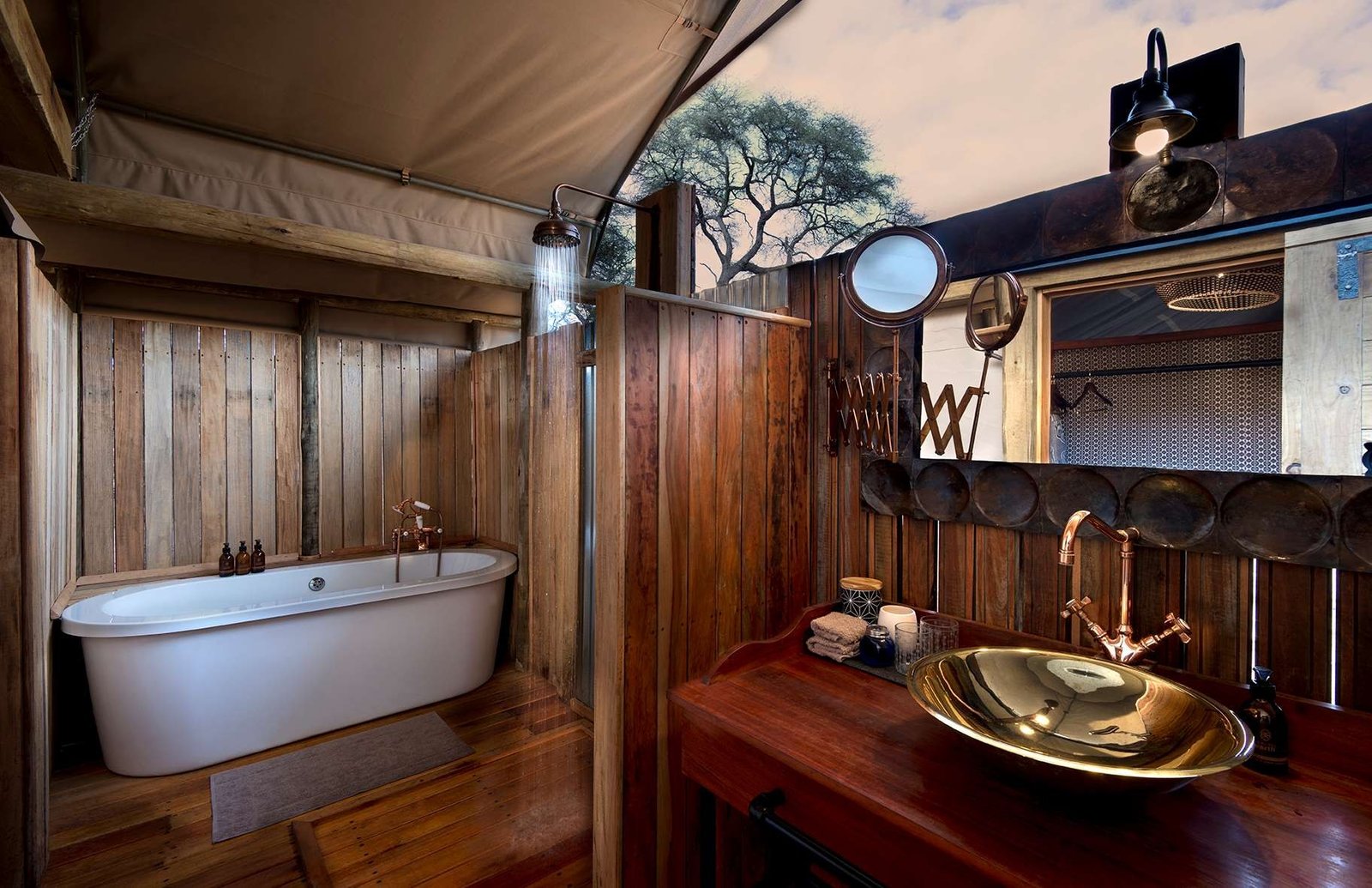 A bathroom at Somalisa Expeditions has a freestanding tub and a copper basin