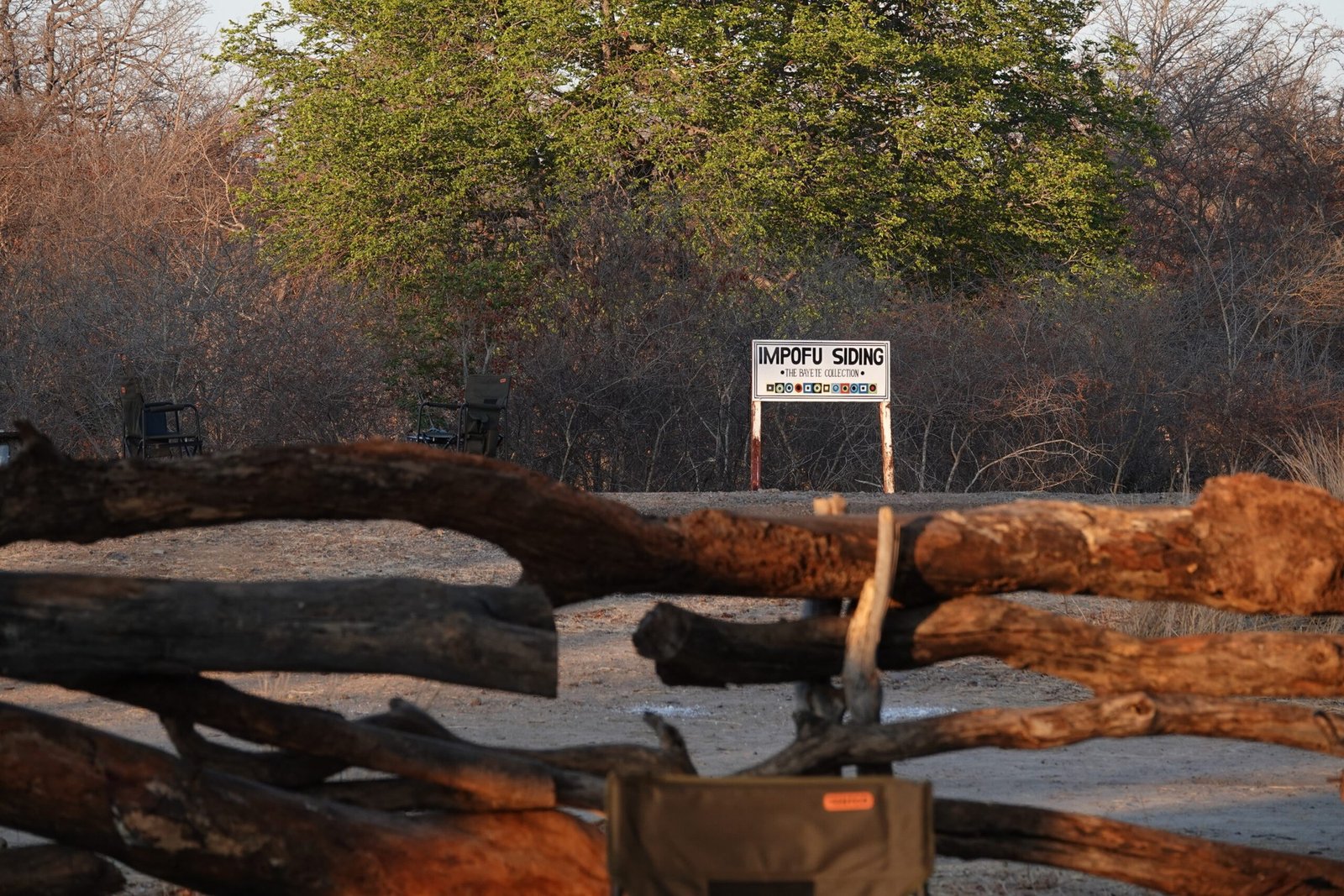 The Impofu Siding sign stands behind a log fence at The Siding